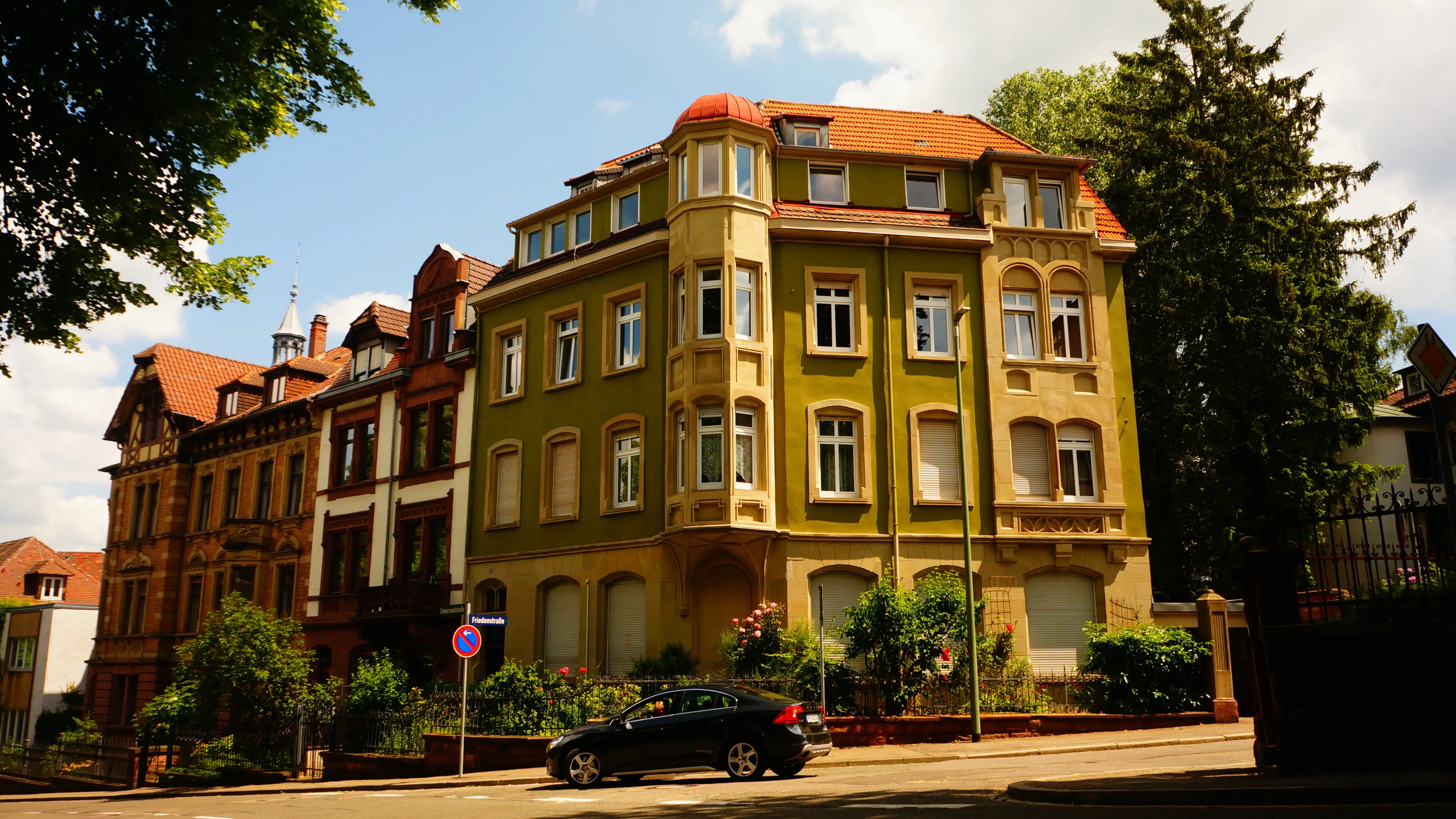 Blick auf ein historisches Wohngebäude in Pforzheim mit gelber Fassade, roten Dächern, grünen Bäumen und klassischer Stadtarchitektur. Das Bild wird auf der Standortseite Pforzheim von GARANT Immobilien verwendet und steht für den regionalen Immobilienmarkt, zentrumsnahe Wohnlagen und Immobilienberatung in Pforzheim, Brötzingen, Büchenbronn, Niefern-Öschelbronn und Umgebung.