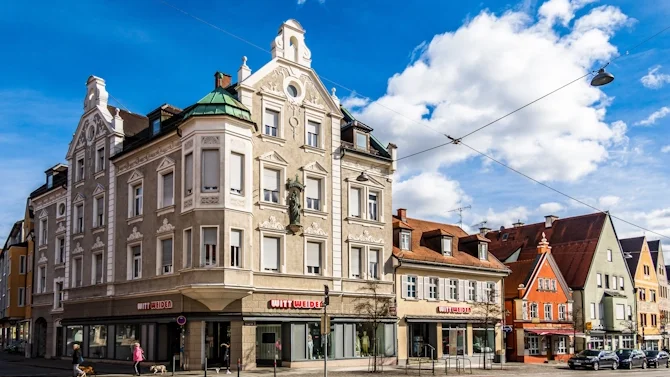Blick auf die Innenstadt von Fürstenfeldbruck mit historischen Gebäuden, hellen Fassaden, roten Dächern und blauem Himmel. Das Bild wird auf der Standortseite Fürstenfeldbruck von GARANT Immobilien verwendet und steht für den regionalen Immobilienmarkt, attraktive Wohnlagen und Immobilienberatung in Fürstenfeldbruck, Germering, Puchheim, Olching und Umgebung.