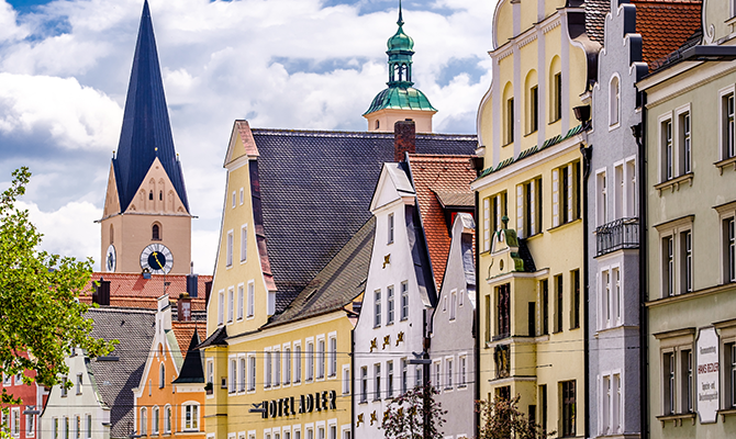 Blick auf die historische Innenstadt von Ingolstadt mit farbigen Fassaden, roten Dächern, Kirchtürmen und klassischer Architektur. Das Bild wird auf der Standortseite Ingolstadt von GARANT Immobilien verwendet und steht für den regionalen Immobilienmarkt, stabile Wohnlagen und Immobilienberatung in Ingolstadt, Neuburg Schrobenhausen, Pfaffenhofen an der Ilm, Eichstätt und Umgebung.