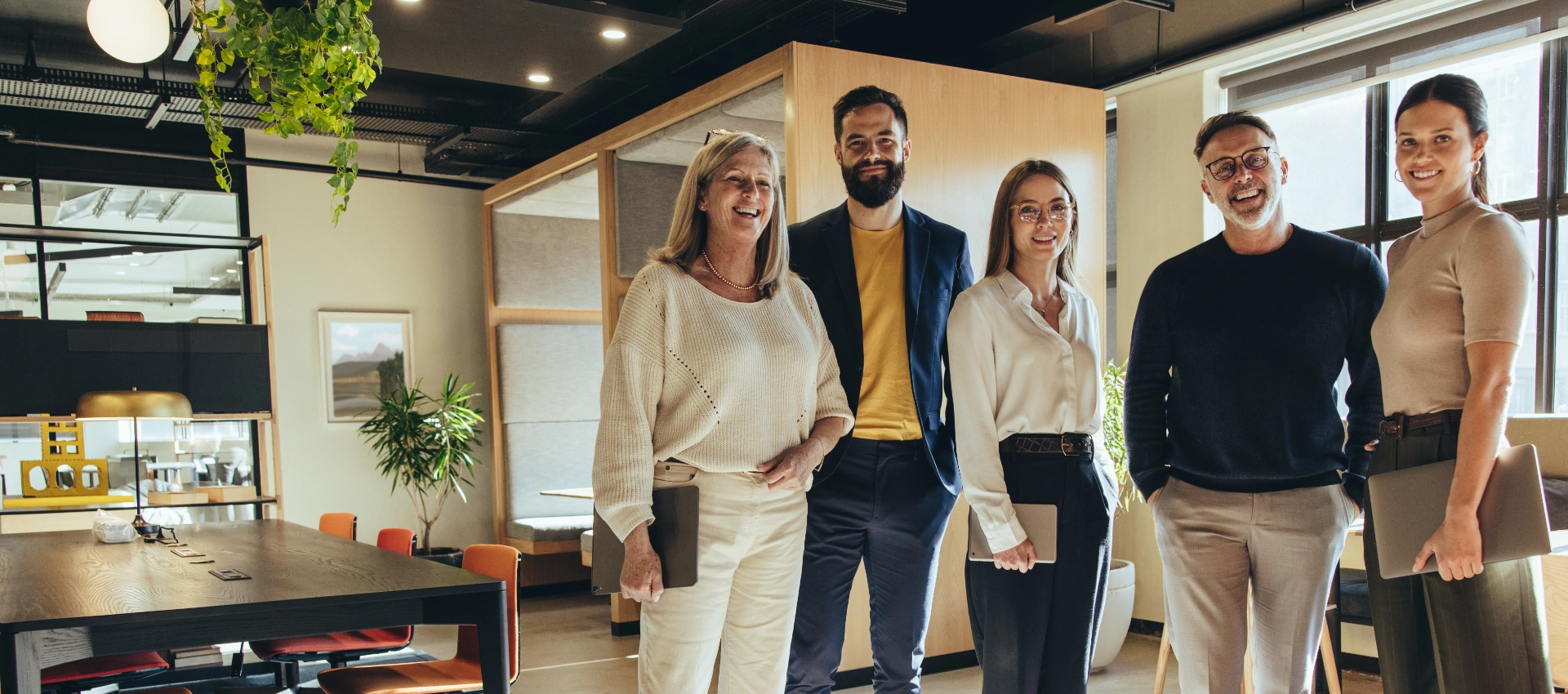 Mehrere Mitarbeitende stehen gemeinsam in einer modernen Büroumgebung. Das Bild wird als Header der Karriere-Seite von GARANT Immobilien verwendet und steht für Teamarbeit, Zusammenarbeit und berufliche Perspektiven im Immobilienbereich.
